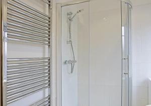 a shower with a glass door in a bathroom at Tynewold in Southwold