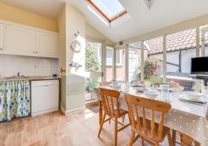 a kitchen and dining room with a table and chairs at Victoria Cottage in Woodbridge