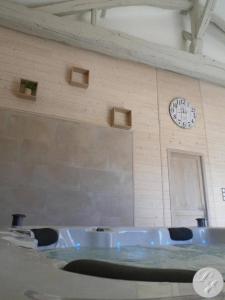 a bathroom with a tub and a clock on the wall at Chambres d'Hôtes L'Escale in Émeringes