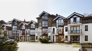 a row of apartment buildings with a parking lot at Nora Green in Nida