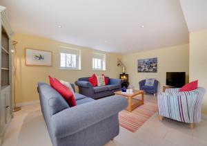 a living room with two couches and a tv at West Barn Cottage in Aldringham