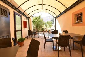 an outdoor dining area with tables and chairs at Hotel Cavour in Olbia