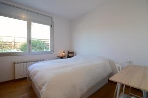 a bedroom with a bed and a table and a window at Ponent in L'Escala +31 photos