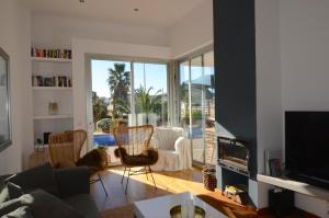 a living room with a couch and chairs and a television at Ponent in L'Escala
