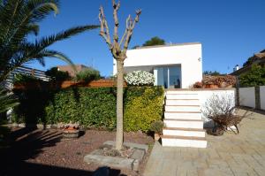 a white house with a palm tree and stairs at Ponent in L'Escala