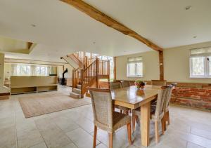 a dining room with a wooden table and chairs at Vale Farm Barns Sutton in Sutton