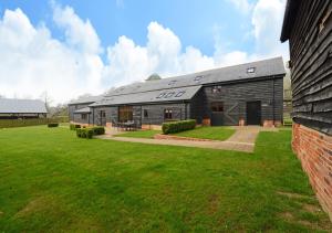 a large building with a grass yard in front of it at Vale Farm Barns Sutton in Sutton