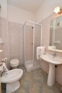 a bathroom with a toilet and a sink and a shower at Hotel Cavour in Olbia