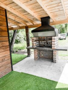 a patio with an outdoor grill with a wooden roof at ENTRE BAMBUES in Los Ángeles