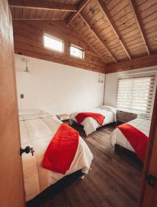 3 camas en una habitación con suelo y ventanas de madera en ENTRE BAMBUES, en Los Ángeles