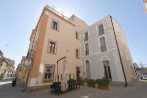 um edifício com mesas e cadeiras em frente em Hotel Cavour em Olbia