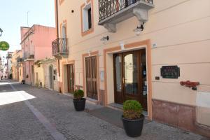 a street with a building with potted plants on it at Hotel Cavour in Olbia
