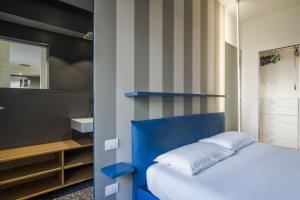 a bedroom with a blue bed and a mirror at Easylife - Confortevole appartamento in Bocconi in Milan