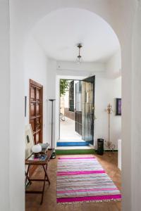 ein Wohnzimmer mit einer offenen Tür und einem Teppich in der Unterkunft Genteel Home Corral del Rey in Sevilla