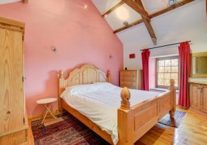 AbercastleにあるTy'r Castellのピンクの壁、ベッド1台付きのベッドルーム1室