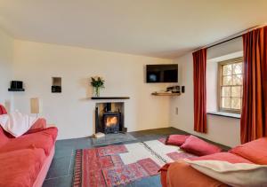 AbercastleにあるTy'r Castellのリビングルーム(赤いソファ、暖炉付)
