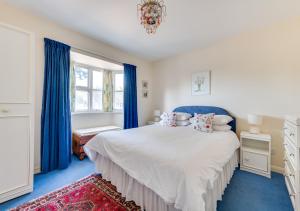 Reydon的住宿－The Spinney，一间卧室配有蓝色地毯和蓝色窗帘的床