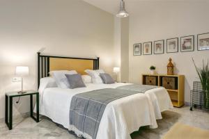 セビリアにあるGenteel Home Tomás de Ibarraのベッドルーム(白いシーツを使用した大型ベッド1台付)
