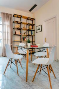 a dining room with white chairs and a table at Genteel Home Tomás de Ibarra in Seville