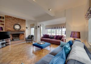 a living room with a blue couch and a fireplace at Tower Cottage in Walberswick
