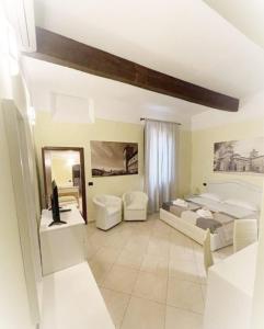 Cette grande chambre comprend 2 lits et un miroir. dans l'établissement DIMORA AL SARACENO, à Ferrare