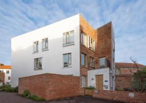 een wit huis met een stenen muur bij Turnstones in Southwold