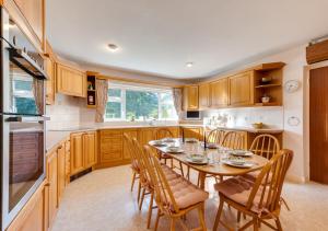 a kitchen with a wooden table and chairs and a kitchen with at Willow House in Halesworth