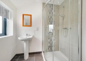 a white bathroom with a sink and a shower at West View in Middleton