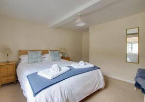 a bedroom with a bed with two towels on it at Wren Cottage in Woodbridge