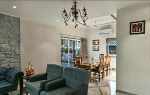 ein Wohnzimmer mit Tisch und Stühlen und einem Kronleuchter in der Unterkunft Meritas Countryside Resort Lonavala in Lonavla