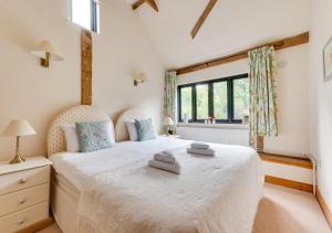 a bedroom with a bed with two towels on it at Willow Cottage at Wattisham Hall in Wattisham