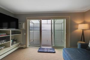 een slaapkamer met een glazen schuifdeur en een balkon bij 209 Water Street Inn in Boyne City