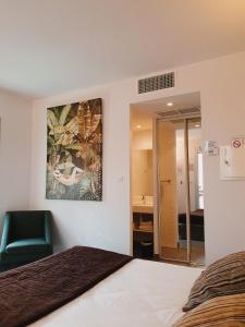 ユゼスにあるパティオ ドゥ ヴィオレットのベッドルーム1室(ベッド1台付)が備わります。壁には絵画が飾られています。