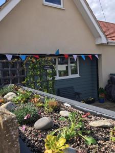 um jardim em frente a uma casa com bandeiras em Nannys Nook whitstable kent em Whitstable