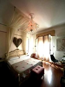 ein Schlafzimmer mit einem großen Bett und einem Kronleuchter in der Unterkunft Casale D' Or in Palermo