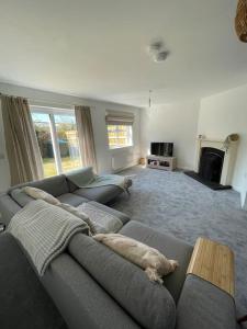 sala de estar con sofá gris y chimenea en Cashel on the Coast, 3 bedroom holiday home, Ballycastle, en Ballycastle