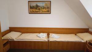 two beds in a room with a picture on the wall at Motel Velký Rybník in Pelhřimov