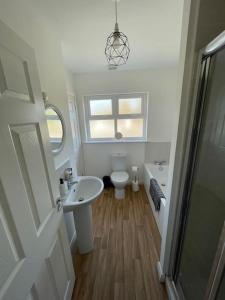 a bathroom with a sink and a toilet and a shower at Cashel on the Coast, 3 bedroom holiday home, Ballycastle in Ballycastle