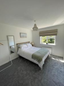 a bedroom with a bed and a mirror and a window at Cashel on the Coast, 3 bedroom holiday home, Ballycastle in Ballycastle