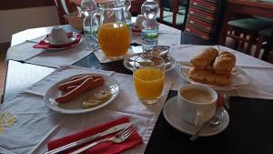 una mesa con platos de comida y una taza de zumo de naranja en Motel Velký Rybník, en Pelhřimov