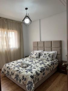 - une chambre avec un lit et une couette bleue et blanche dans l'établissement Appartement moderne avec piscine à Marrakech, à Marrakech