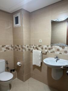 La salle de bains est pourvue de toilettes et d'un lavabo. dans l'établissement Appartement moderne avec piscine à Marrakech, à Marrakech