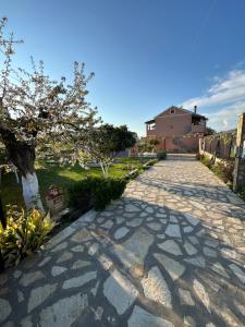 brukowany podjazd z drzewem i domem w obiekcie Telis Apartments One w Rodzie