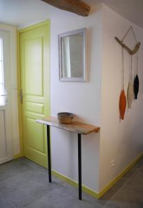 um quarto com uma mesa e uma porta verde em Art et Nature em Abbeville