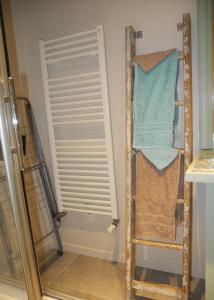 uma casa de banho com um armário com uma porta e toalhas em Art et Nature em Abbeville