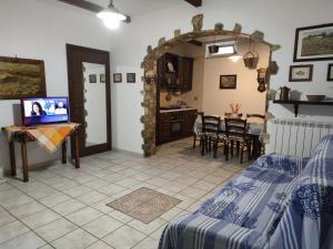 sala de estar con cama y mesa con TV en Villa Frantoio en Mattinata