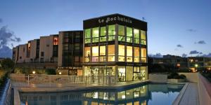a building with a pool in front of a building at Logis Hôtel Le Rochelois in La Rochelle