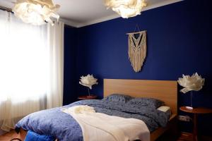 ein blaues Schlafzimmer mit einem Bett mit blauen Wänden in der Unterkunft Cichy apartament w centrum Nowy Sącz in Nowy Sącz