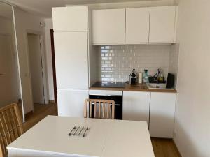 a kitchen with white cabinets and a white table at Walk to Beach T2 Climatisé, Vue mer, Parking Privé in Roquebrune-Cap-Martin
