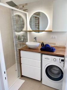 a bathroom with a sink and a washing machine at Walk to Beach T2 Climatisé, Vue mer, Parking Privé in Roquebrune-Cap-Martin